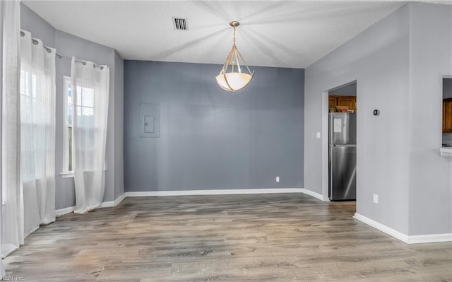 empty room with hardwood / wood-style floors and a textured ceiling