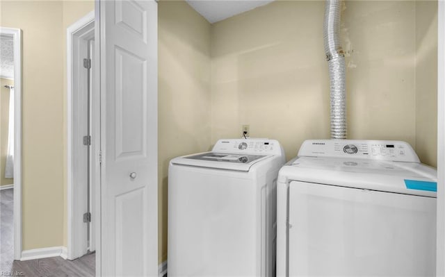 washroom with light wood-type flooring and separate washer and dryer