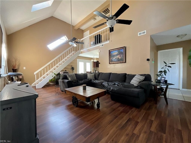 living room with ceiling fan, dark hardwood / wood-style flooring, high vaulted ceiling, and a skylight