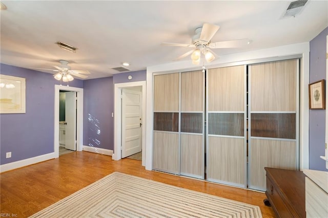 interior space with ceiling fan, ensuite bathroom, and light wood-type flooring