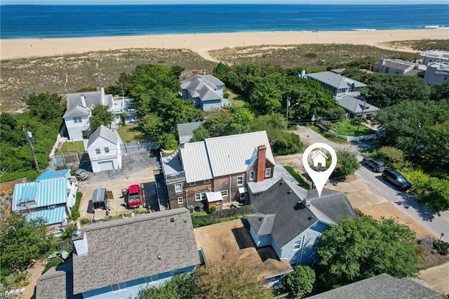 drone / aerial view with a water view and a beach view