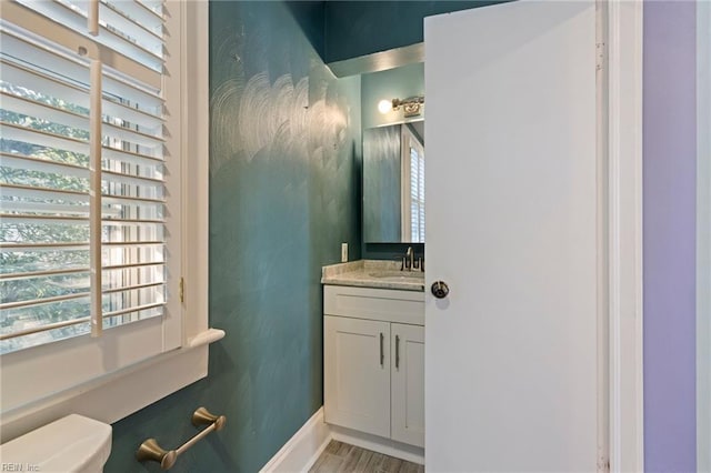 bathroom with vanity, hardwood / wood-style flooring, and toilet