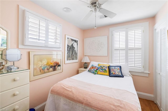 bedroom with ceiling fan, a closet, and hardwood / wood-style flooring