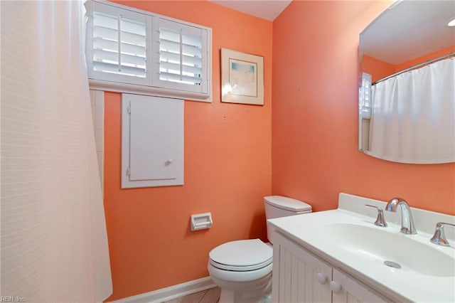 bathroom with tile patterned floors, vanity, a healthy amount of sunlight, and toilet