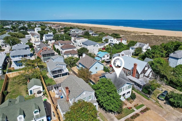 birds eye view of property with a water view and a beach view