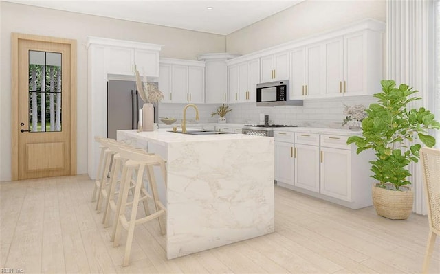 kitchen featuring white cabinets, a center island with sink, and sink