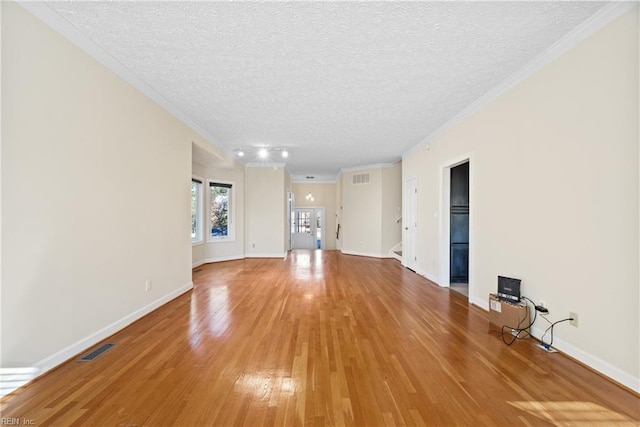 unfurnished living room featuring ornamental molding, hardwood / wood-style floors, and a textured ceiling