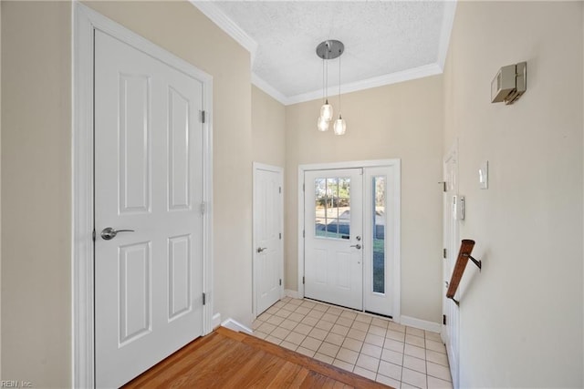 entryway featuring ornamental molding, a textured ceiling, and light tile patterned flooring