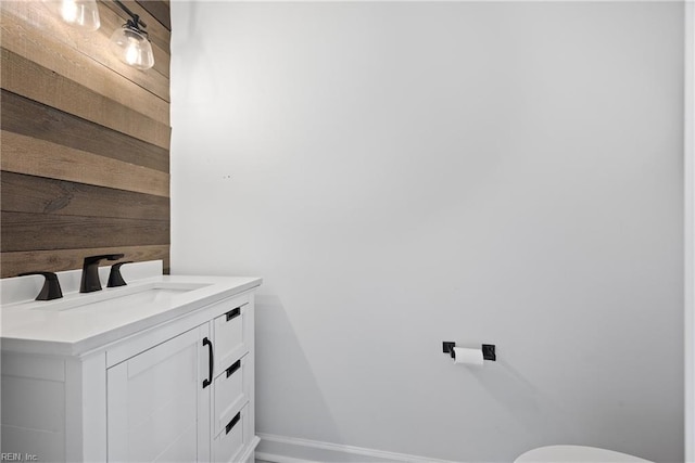 bathroom with vanity and wooden walls