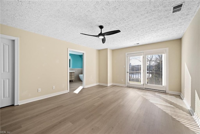 spare room with hardwood / wood-style flooring, ceiling fan, and a textured ceiling