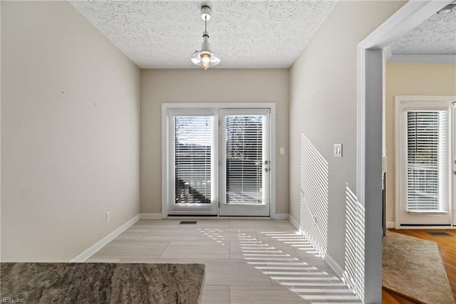 doorway featuring light tile patterned flooring and a textured ceiling