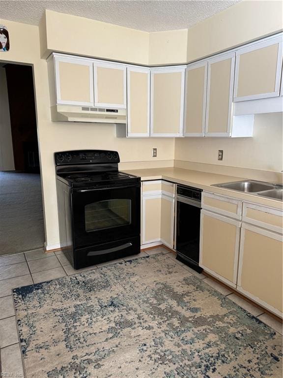 kitchen featuring electric range, sink, light tile patterned floors, and a textured ceiling