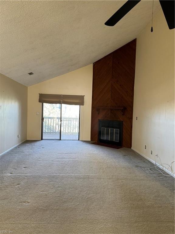 unfurnished living room featuring vaulted ceiling, ceiling fan, a textured ceiling, a fireplace, and light colored carpet