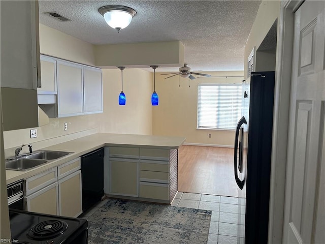 kitchen with pendant lighting, sink, black dishwasher, fridge, and kitchen peninsula