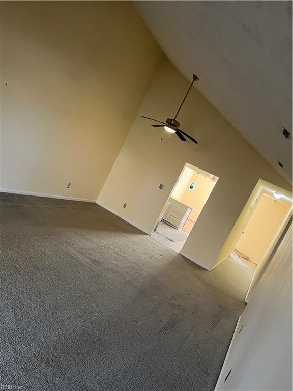 unfurnished living room featuring carpet flooring, high vaulted ceiling, and ceiling fan