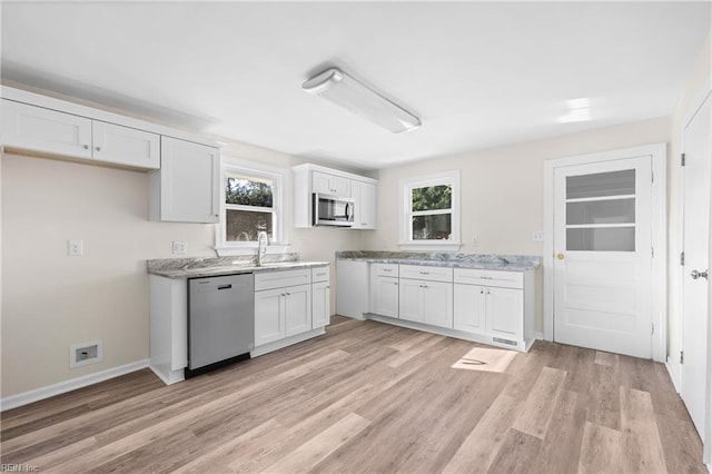 kitchen featuring a wealth of natural light, light hardwood / wood-style flooring, white cabinets, and stainless steel appliances