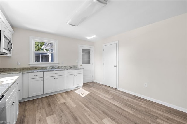 kitchen featuring white cabinets, light stone countertops, and stainless steel appliances