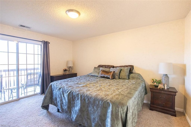 carpeted bedroom featuring access to exterior and a textured ceiling