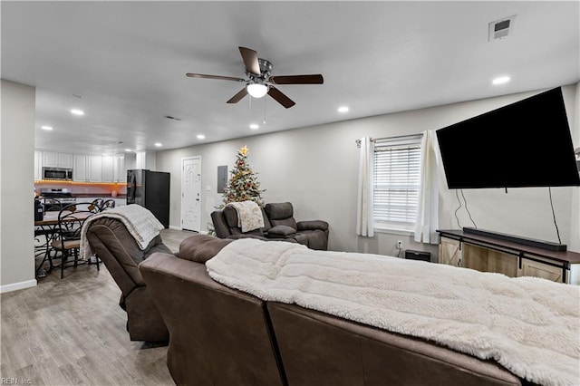 living room featuring electric panel, ceiling fan, and light wood-type flooring