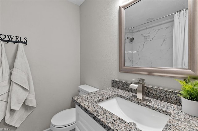 bathroom featuring curtained shower, vanity, and toilet