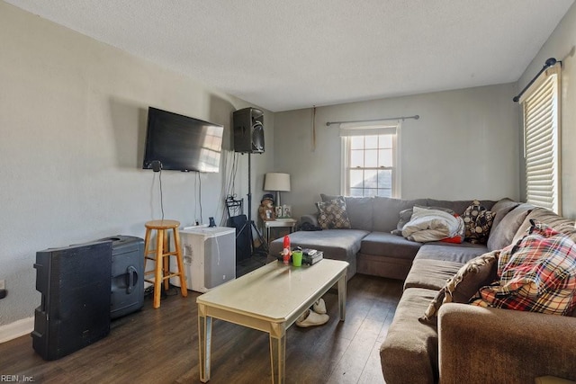 living room with a textured ceiling and dark hardwood / wood-style floors