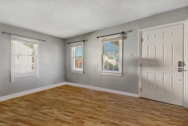 spare room featuring hardwood / wood-style flooring and a textured ceiling