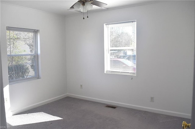 carpeted spare room with a wealth of natural light and ceiling fan