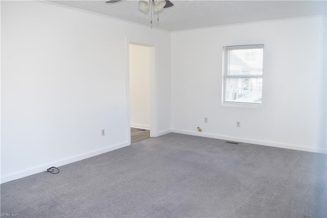 carpeted spare room with ceiling fan