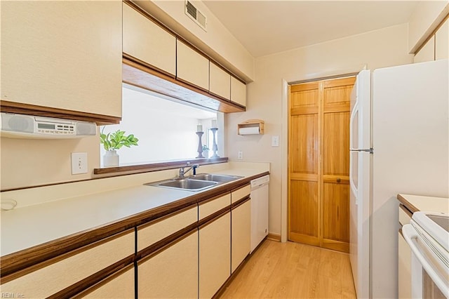 kitchen featuring visible vents, light wood-style flooring, a sink, light countertops, and white cabinetry