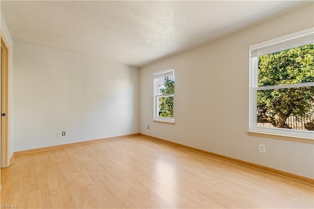 empty room featuring baseboards and light wood-style floors