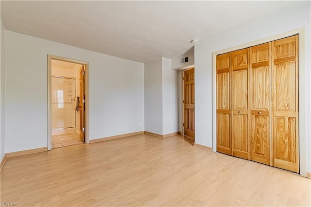 unfurnished bedroom with visible vents, light wood-type flooring, and baseboards