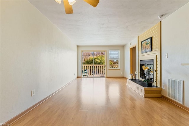 unfurnished living room featuring light hardwood / wood-style flooring and ceiling fan