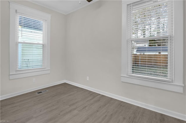 spare room featuring hardwood / wood-style floors, ceiling fan, and crown molding