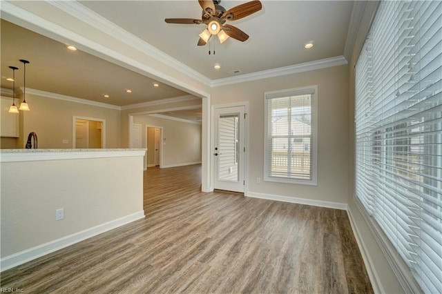 unfurnished living room featuring ceiling fan, ornamental molding, and hardwood / wood-style flooring