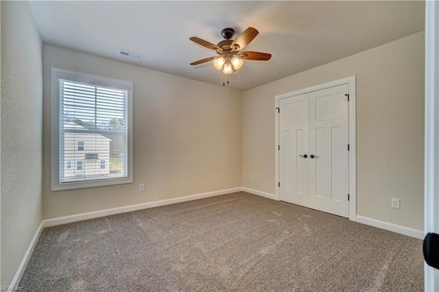 unfurnished bedroom featuring carpet, a closet, and ceiling fan