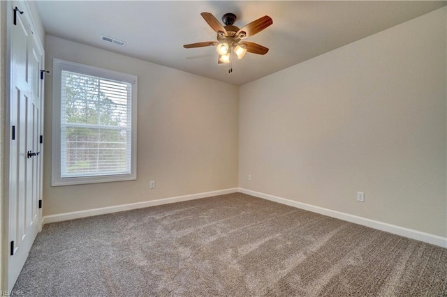 carpeted spare room featuring ceiling fan