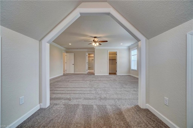 interior space with light carpet, crown molding, ceiling fan, and a textured ceiling