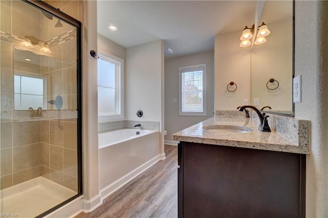 bathroom with hardwood / wood-style floors, vanity, and plus walk in shower