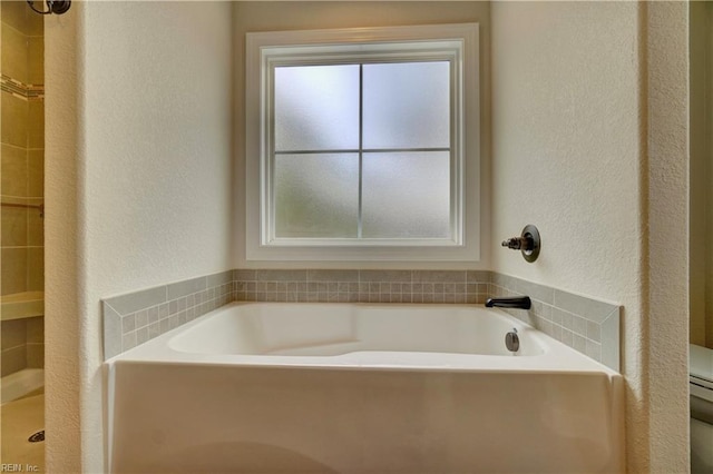 bathroom featuring separate shower and tub and toilet