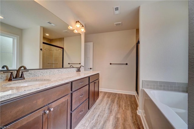 bathroom featuring shower with separate bathtub, vanity, and hardwood / wood-style flooring