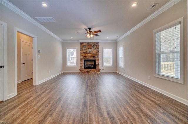 unfurnished living room with a healthy amount of sunlight, a stone fireplace, and ornamental molding