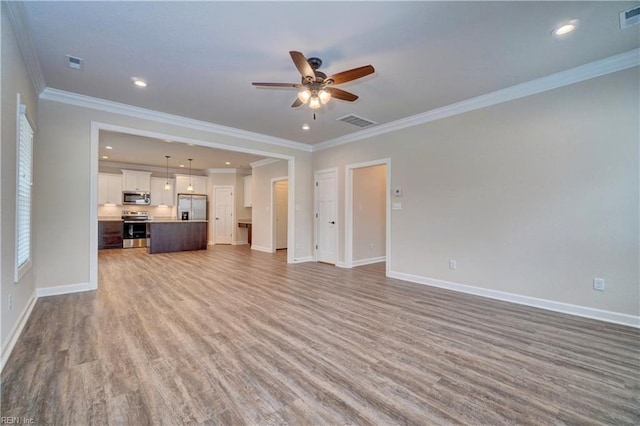 unfurnished living room featuring ceiling fan, wood-type flooring, and ornamental molding