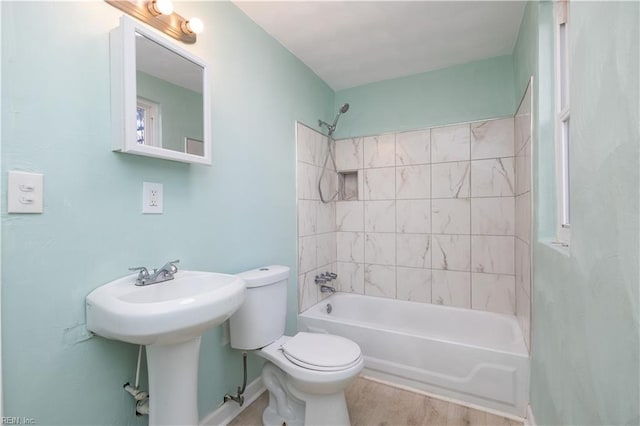 full bathroom featuring hardwood / wood-style flooring, toilet, sink, and tiled shower / bath