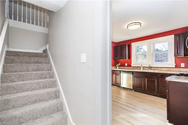 staircase featuring sink and wood-type flooring