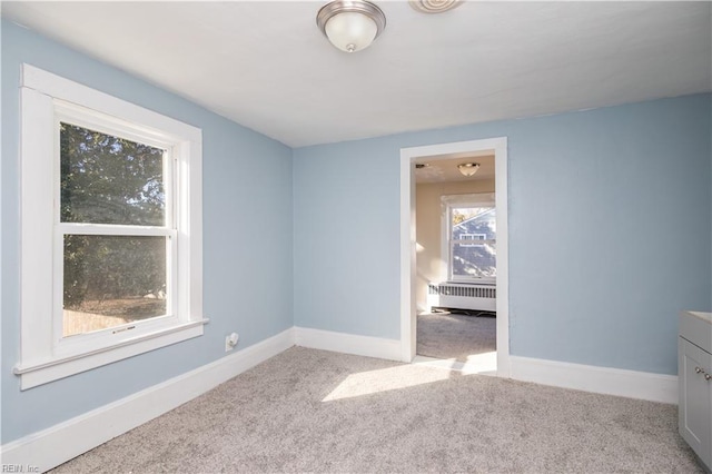 unfurnished bedroom featuring radiator and light colored carpet