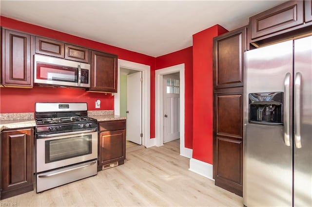 kitchen featuring stainless steel appliances and light hardwood / wood-style floors