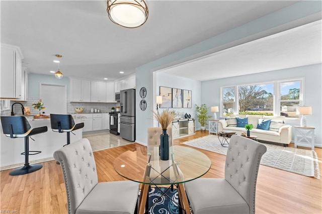 dining space featuring light hardwood / wood-style flooring and sink