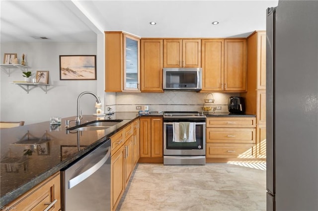 kitchen with appliances with stainless steel finishes, tasteful backsplash, dark stone countertops, and sink