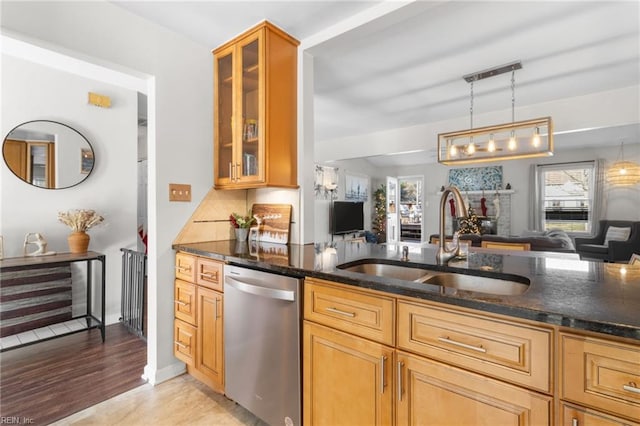 kitchen featuring pendant lighting, dishwasher, backsplash, sink, and dark stone countertops