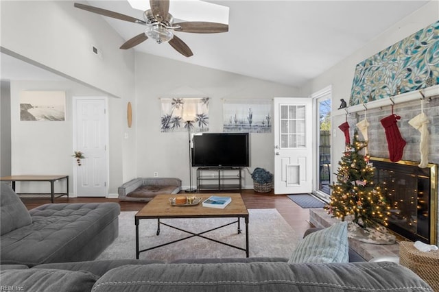 living room with ceiling fan, dark hardwood / wood-style flooring, and vaulted ceiling